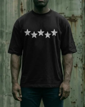 hombre de frente usando playera negra oversize estampado estrellas high standard