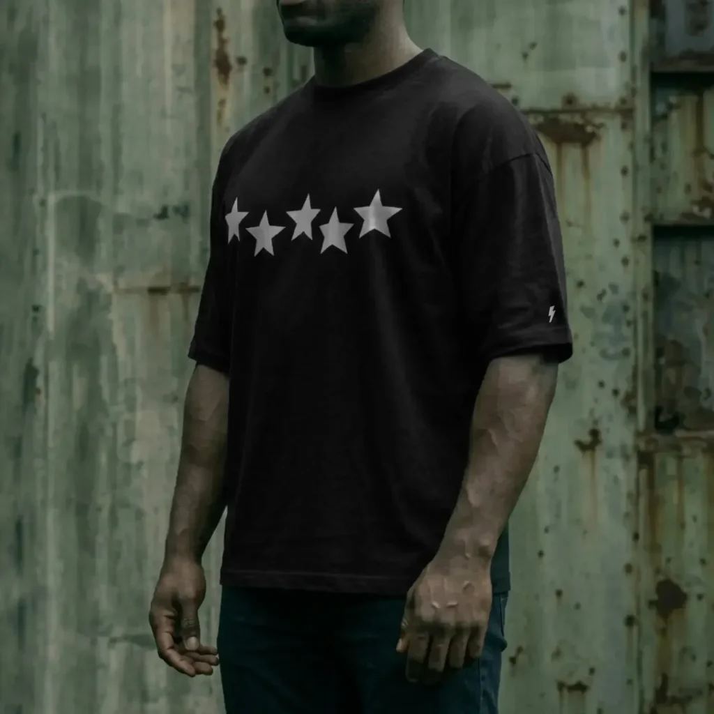 hombre de perfil usando playera negra oversize estampado estrellas high standard