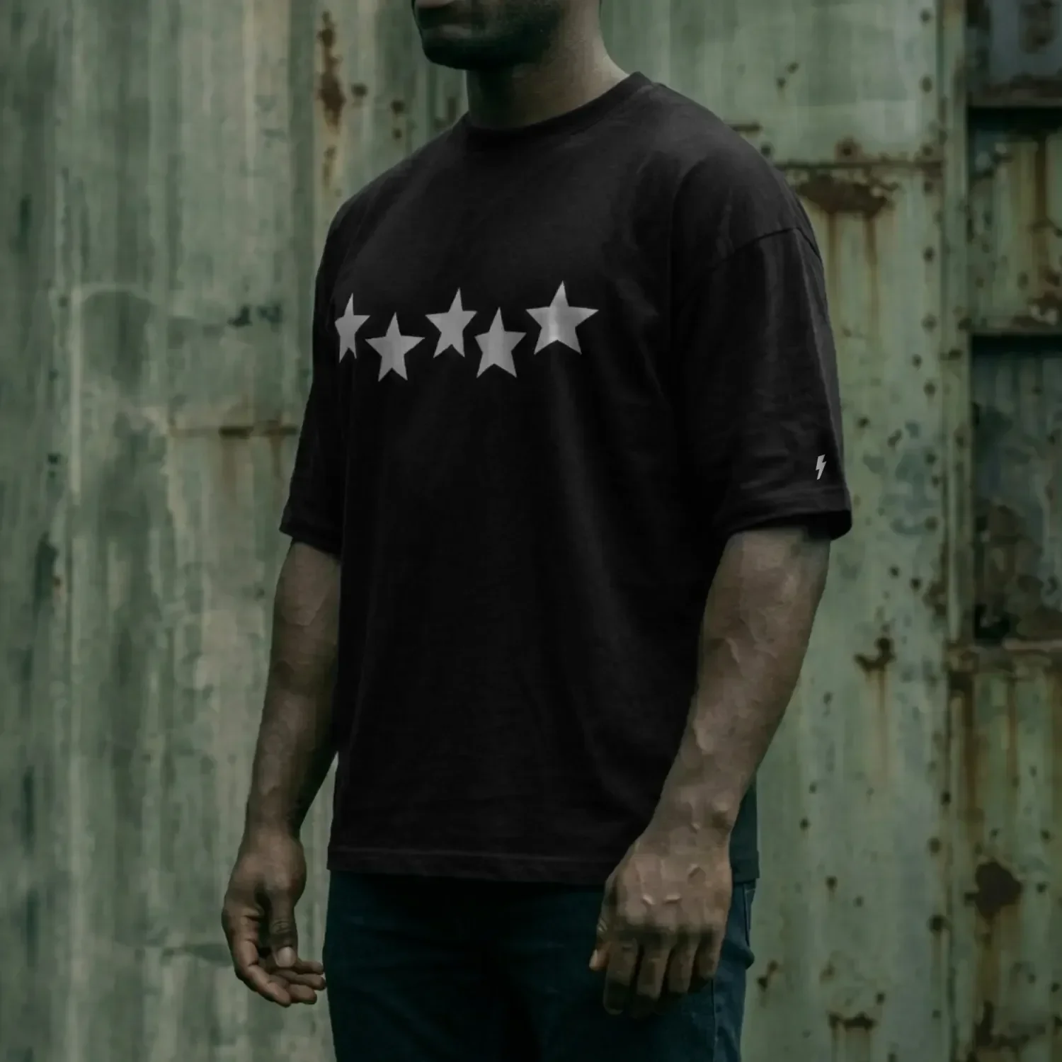 hombre de perfil usando playera negra oversize estampado estrellas high standard